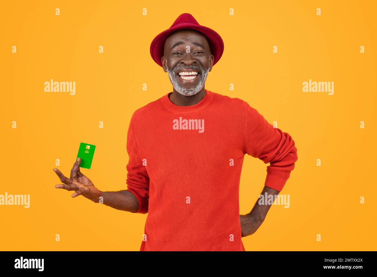 A cheerful senior black man with a bright white smile, wearing a red hat and sweater Stock Photo