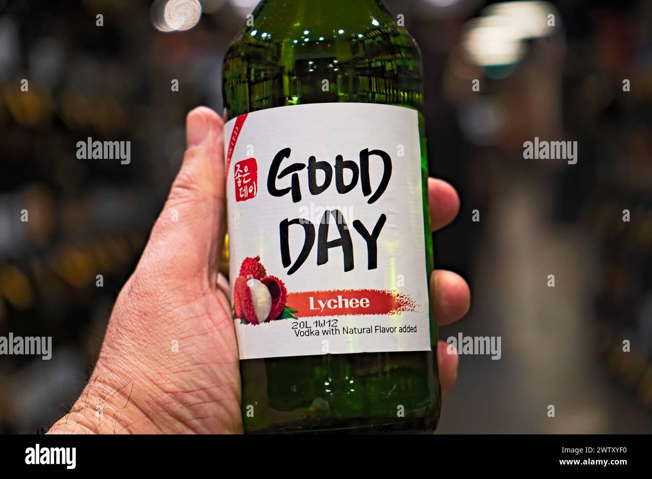 Honolulu, HI - Dec 24, 2023 : Good Day brand lychee flavored soju or noju bottle and label in hand imported to he United States, known as Korean vodka. Stock Photo