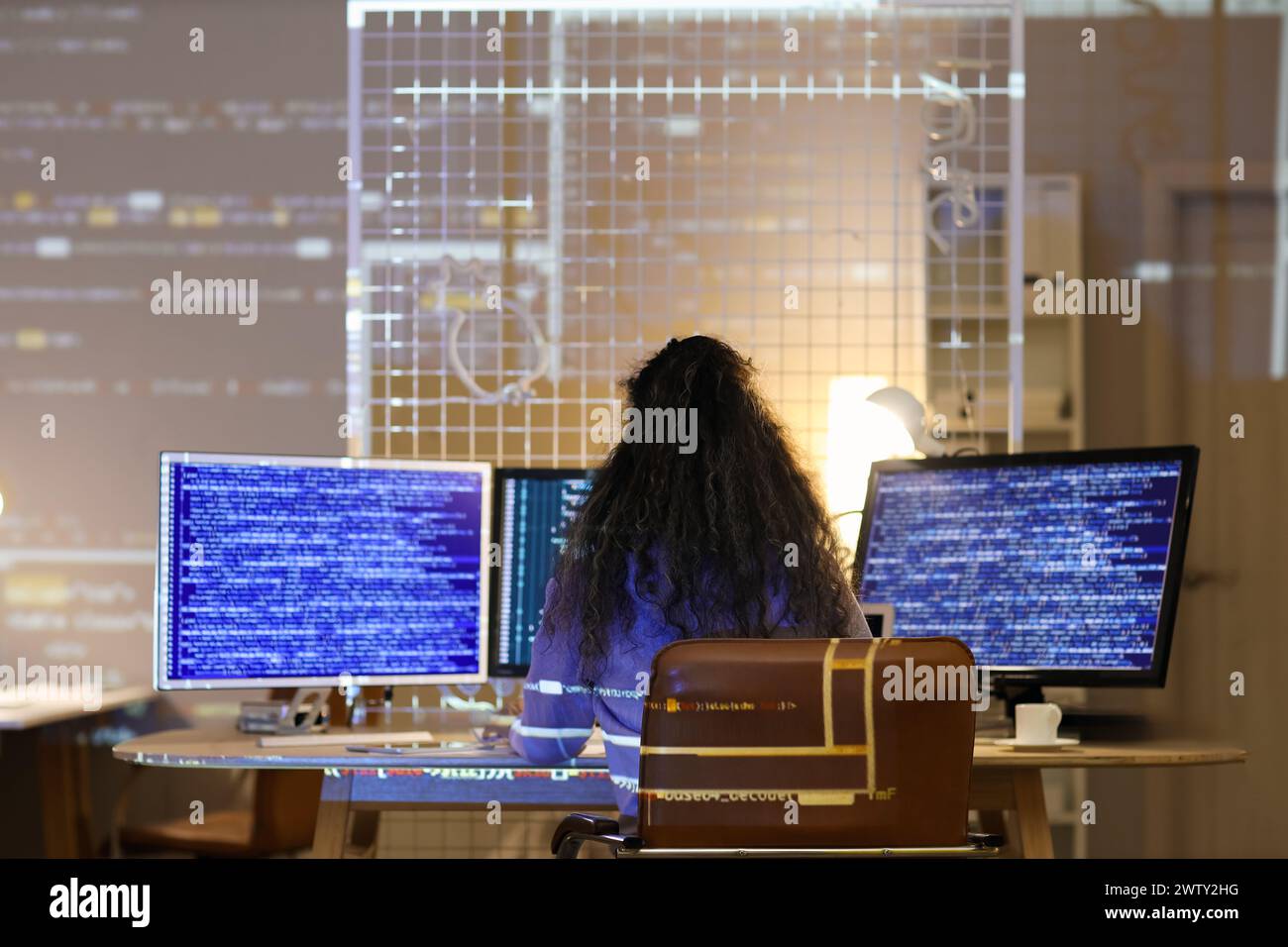 Female programmer with computer monitors working in office at night ...