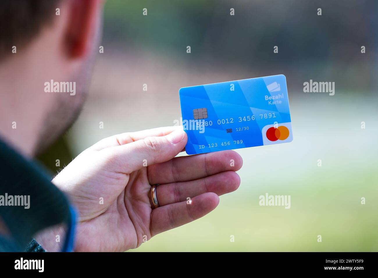 Munich, Bavaria, Germany - March 20, 2024: A hand holds the new Bavarian payment card for asylum seekers which was presented at the press conference on March 20 2024 in Munich *** Eine Hand hält die neue bayerische Bezahlkarte für Asylbewerber welche auf der Pressekonferenz vom 20 2024 März in München vorgestellt wurde Stock Photo