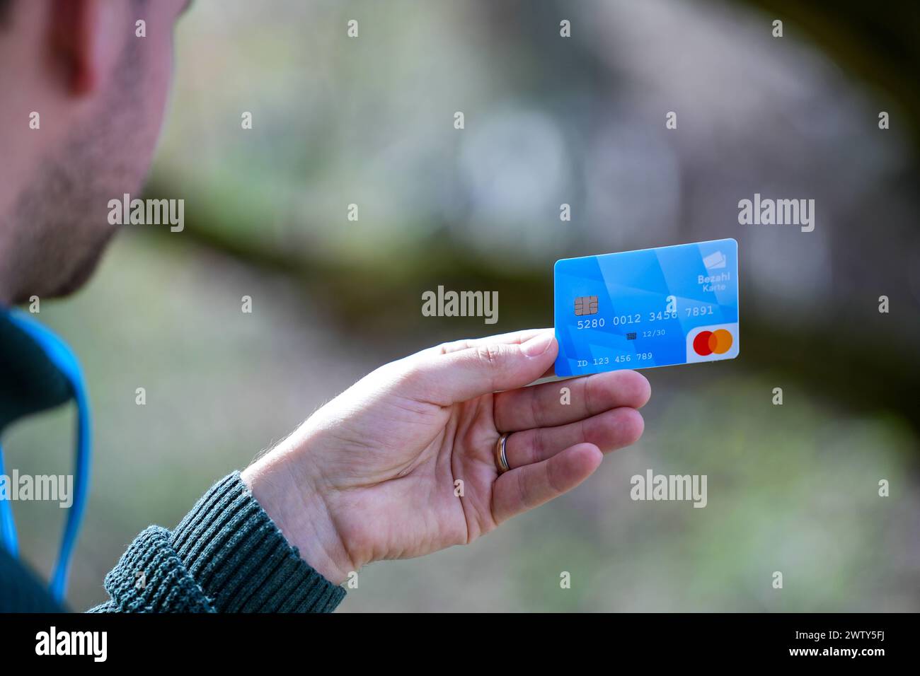 Munich, Bavaria, Germany - March 20, 2024: A hand holds the new Bavarian payment card for asylum seekers which was presented at the press conference on March 20 2024 in Munich *** Eine Hand hält die neue bayerische Bezahlkarte für Asylbewerber welche auf der Pressekonferenz vom 20 2024 März in München vorgestellt wurde Stock Photo