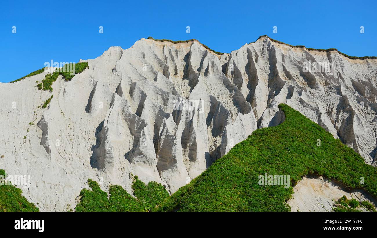 Amazing white mountains with green grass. Clip. Beautiful patterns on rocky white mountain with bright greenery on sunny summer day. White rocks of Stock Photo