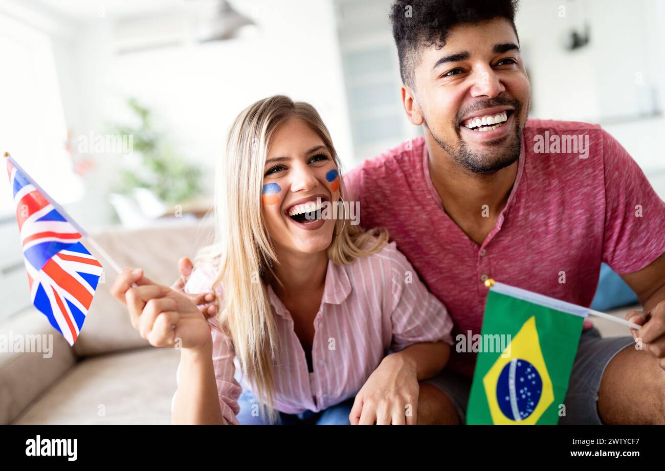 Couple, sports, entretainment and happiness concept. Happy couple cheering at home Stock Photo