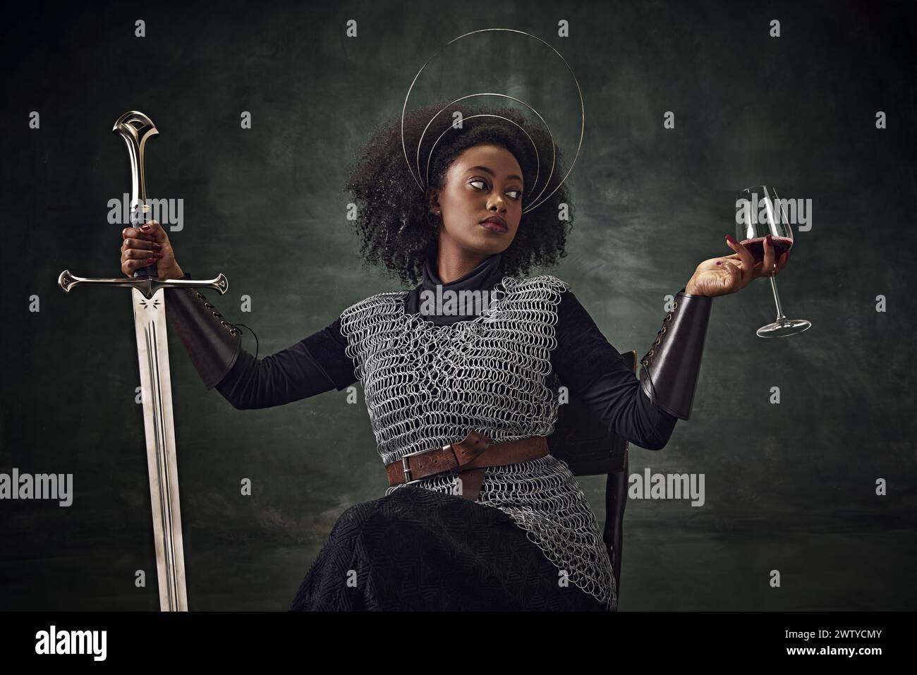 African woman, medieval warrior in chainmail armor sitting on chair ...