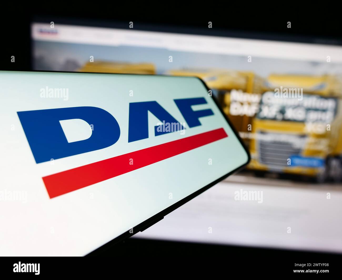 Smartphone with logo of Dutch truck manufacturing company DAF Trucks N.V. in front of business website. Focus on center-left of phone display. Stock Photo