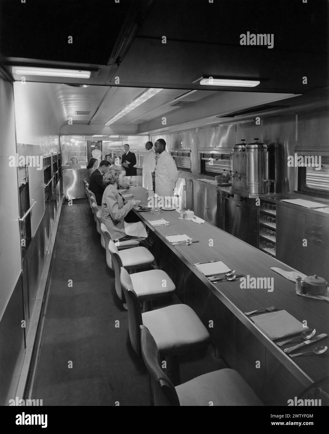 Interior view of people eating in one of the dining cars in which a Fred Harvey business was operating on the Santa Fe Railway Stock Photo