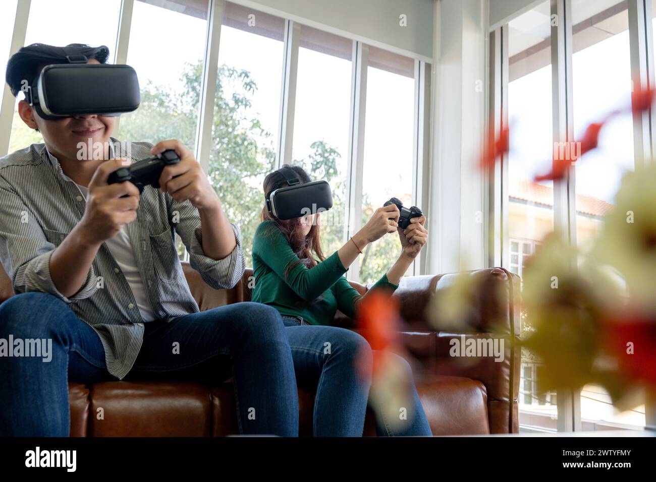 The young couple is having a great time playing VR games at home Stock Photo