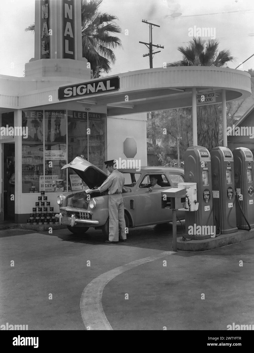 Service station attendant checking the oil of a customer at a Signal Oil gas station situated at the corner of Olympic and Magnolia Boulevards in Los Angeles, California Stock Photo