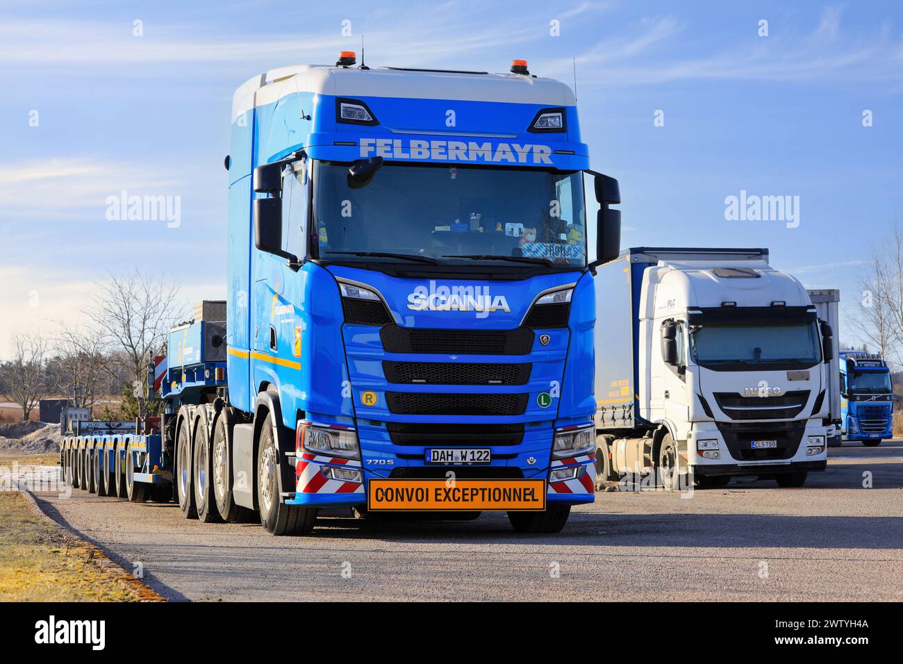 Customized blue Scania 770S truck Felbermayr in front of multi-axled heavy haul trailer parked on truck stop yard. Salo, Finland. March 10, 2024. Stock Photo
