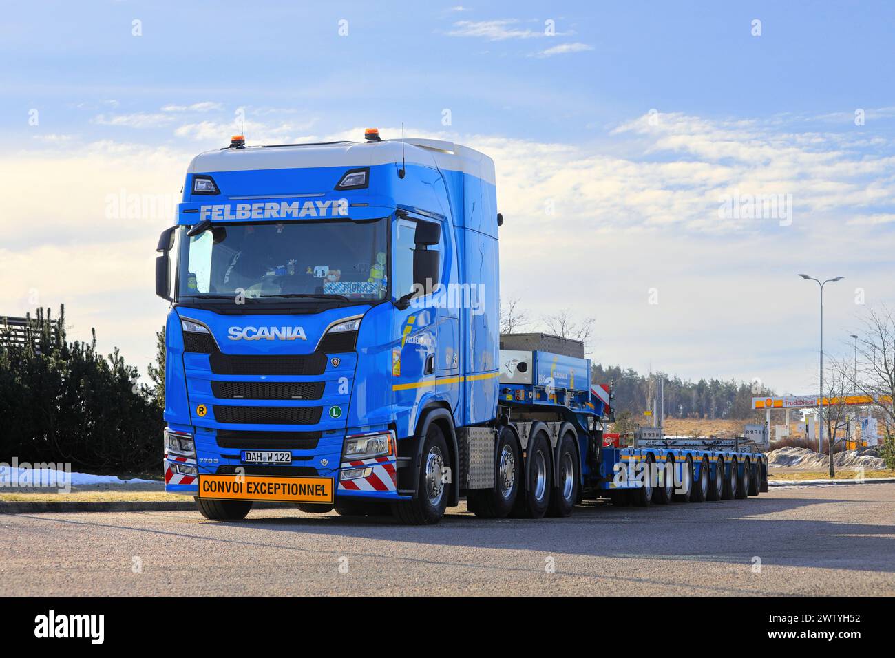 Customized blue Scania 770S truck Felbermayr in front of multi-axled heavy haul trailer parked on truck stop yard. Salo, Finland. March 9, 2024. Stock Photo