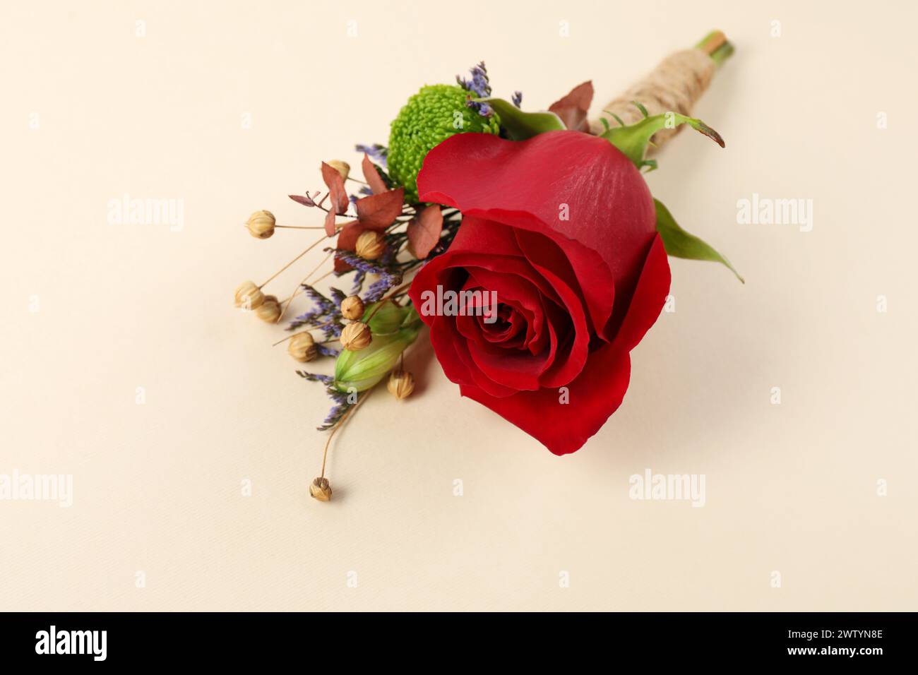 Stylish boutonniere with red rose on beige background, closeup Stock Photo