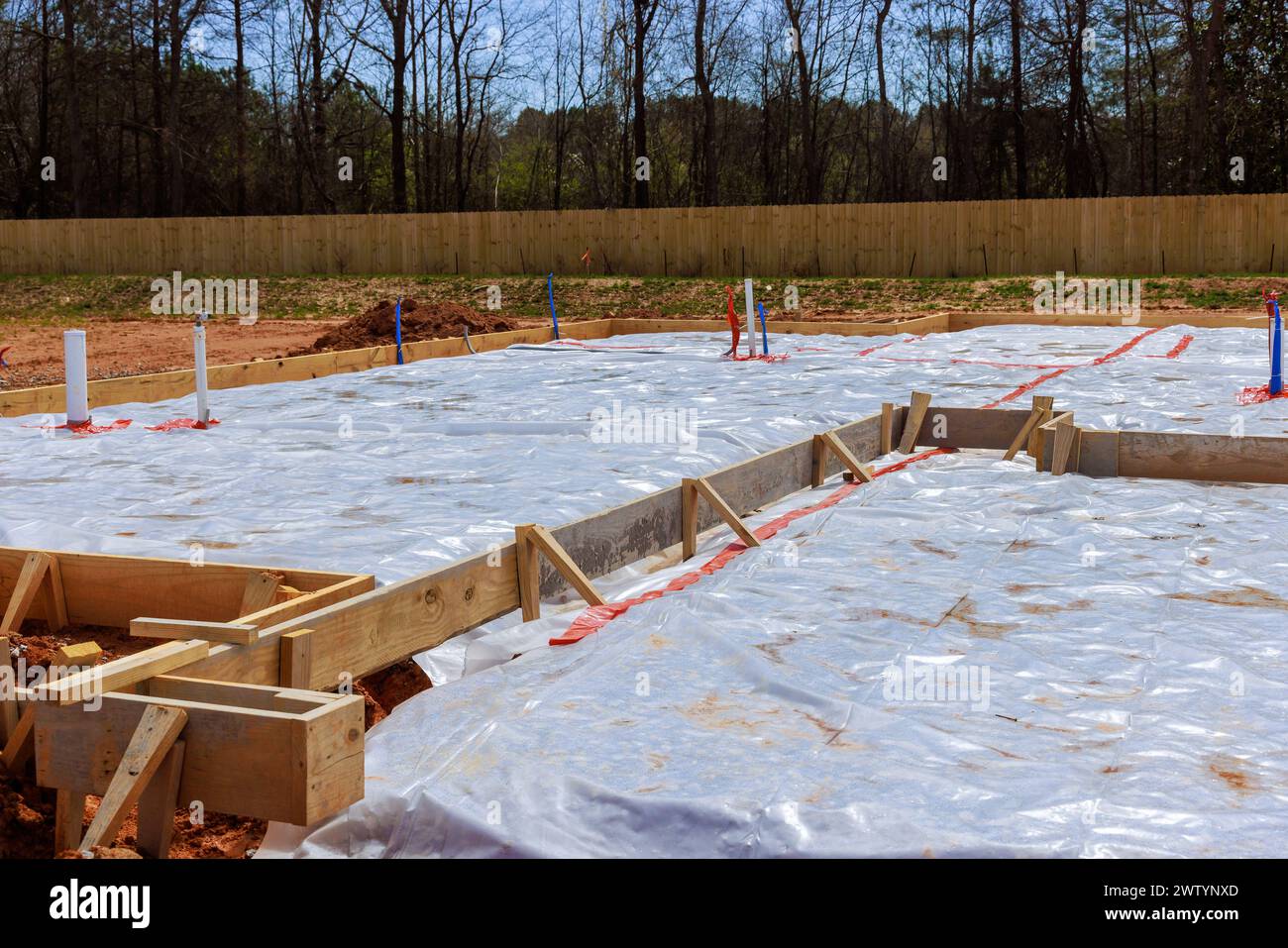 Before pouring foundation for house, ground is covered with first layer of insulation waterproofing. Stock Photo