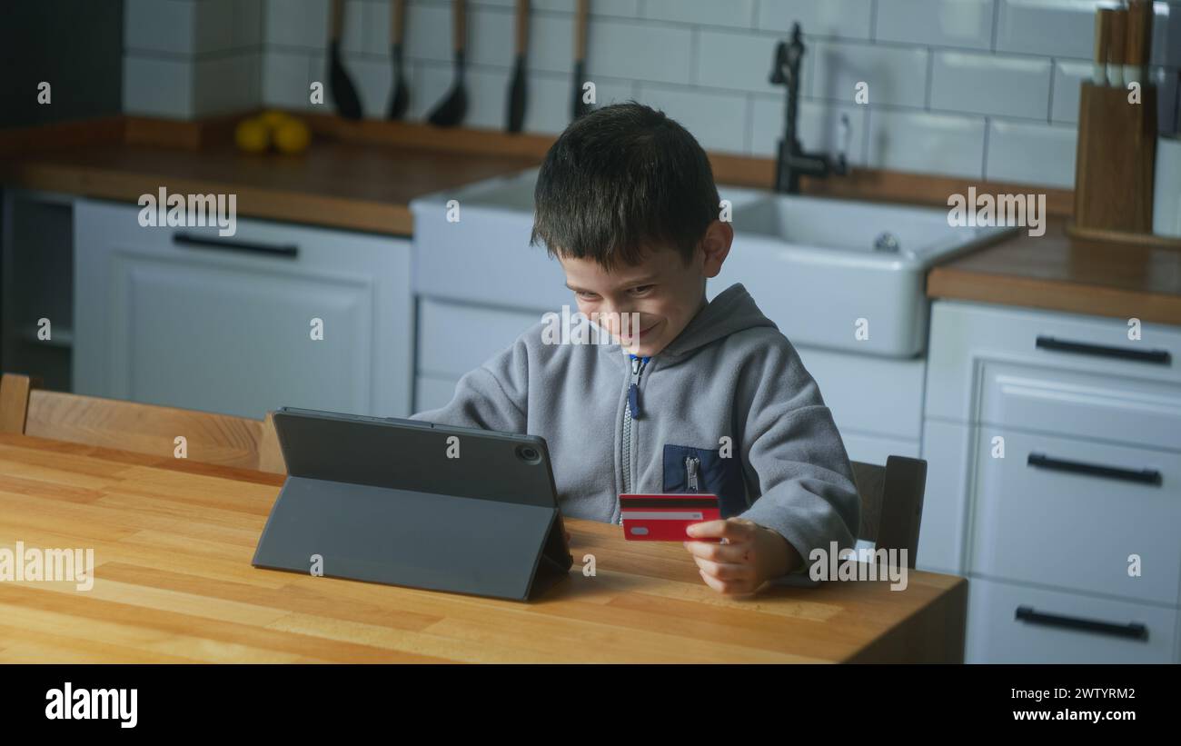 Sneaky little boy buys toys or video game with tablet computer in