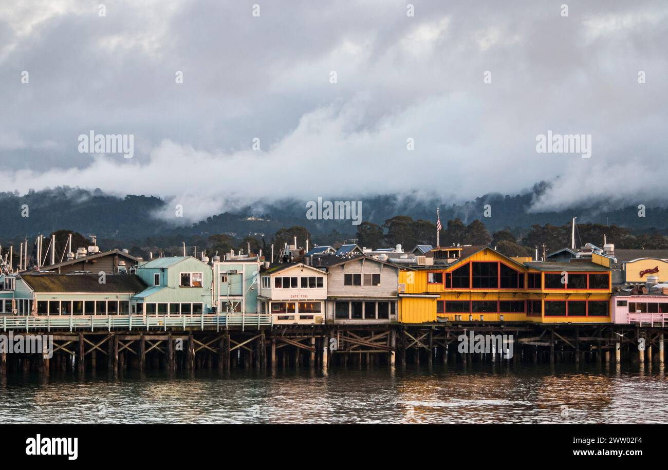 Colourful buildings with shops and restaurants line the famous fisherman's wharf overlooking the harbor in Monterey, California Stock Photo