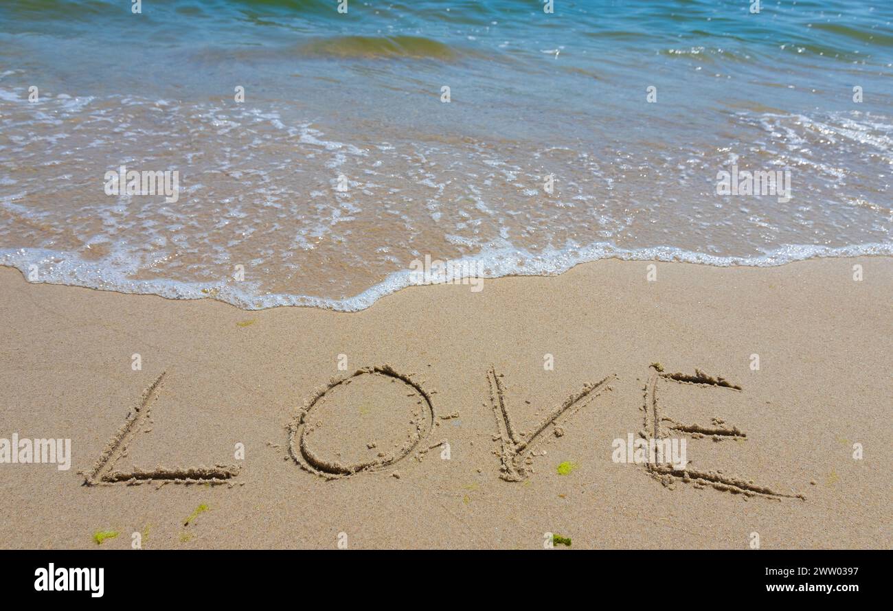 Inscription Love drawn on the sand. Concept of true and honest romantic feelings. spa novel on the sea. Stock Photo