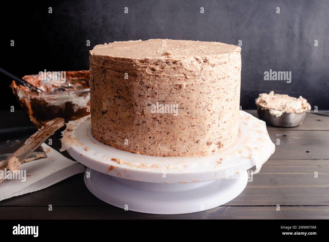 Chocolate Cake Crumb-Coated with Hazelnut Buttercream Frosting: Layer cake frosted with hazelnut Swiss meringue buttercream icing on a cake stand Stock Photo