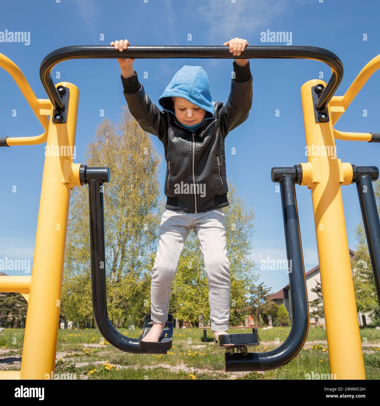 A little boy is exercising outdoors on an air walker gym equipment. Stock Photo
