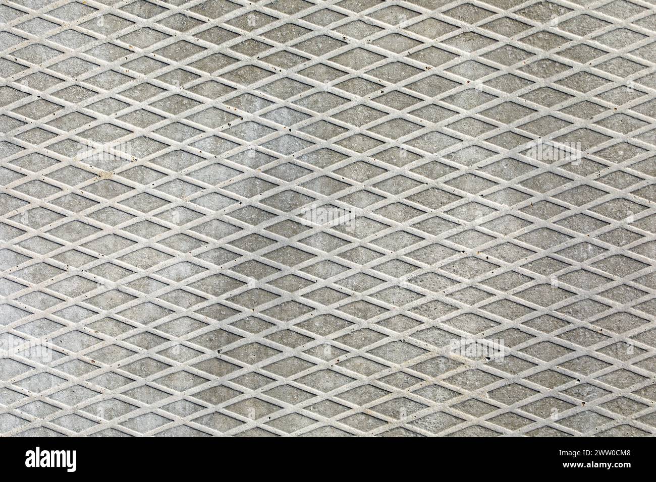 Background of the concrete pavement texture, diagonal and rhombus patterns. Grey colour concrete tile, in close up. Stock Photo