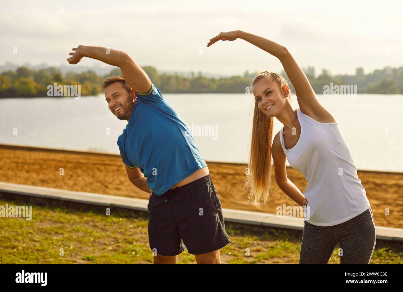 Young fit and active couple doing sport exercising in nature. Outdoors fitness concept. Stock Photo
