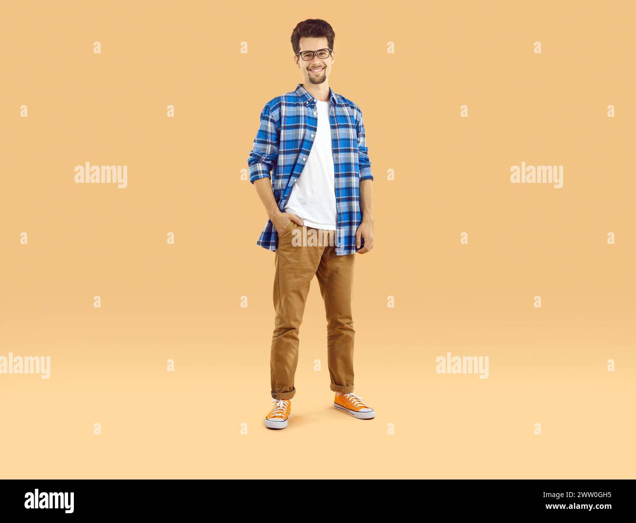 Portrait of a happy male student in glasses and casual clothes standing ...