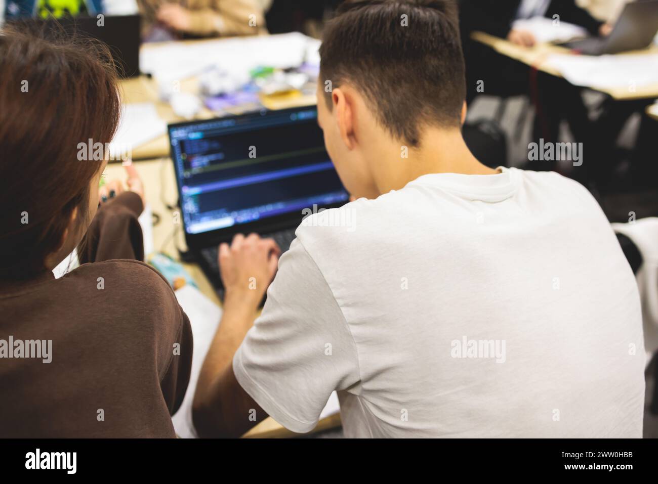 Software developer students in auditorium hall working on computer and laptop, programming contest hackathon competition, pc with coding program app, Stock Photo