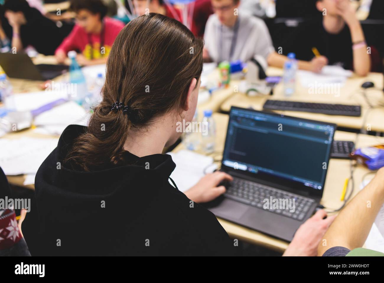 Software developer students in auditorium hall working on computer and laptop, programming contest hackathon competition, pc with coding program app, Stock Photo