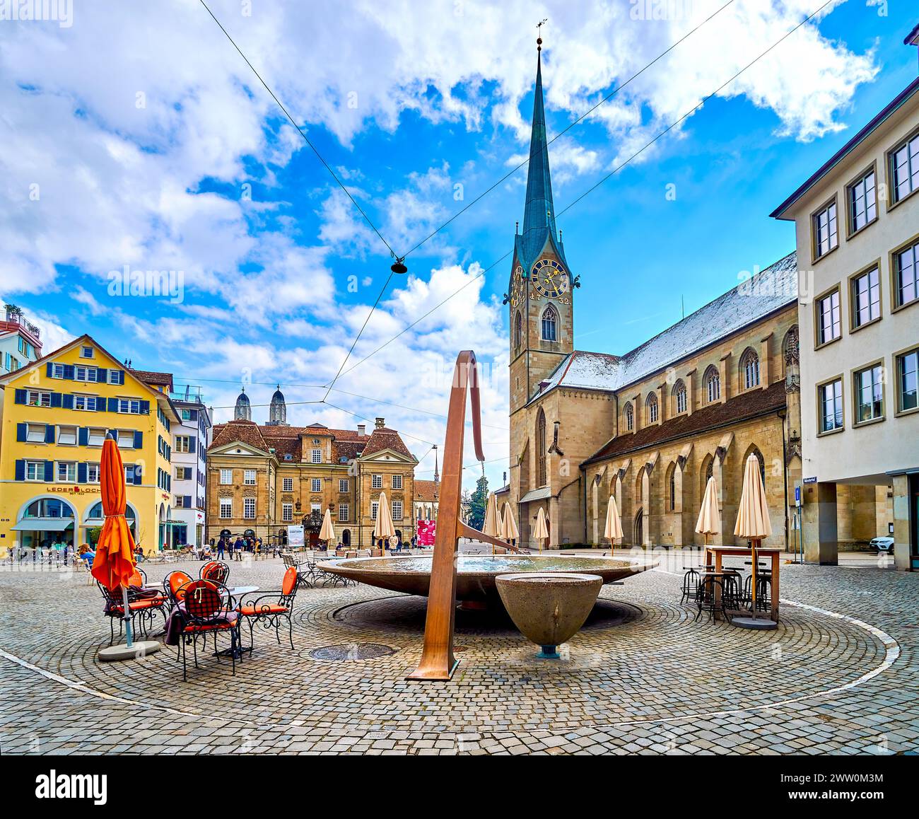 ZURICH, SWITZERLAND - APRIL 3, 2022: Munsterhof Brunnen fountain and Fraumunster church on background, Munsterhof square, on April 3 in Zurich, Switze Stock Photo