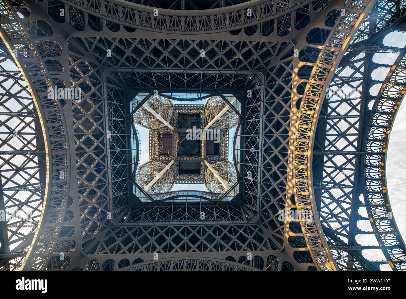The Eiffel Tower stands tall against the blue sky in Paris. Stock Photo