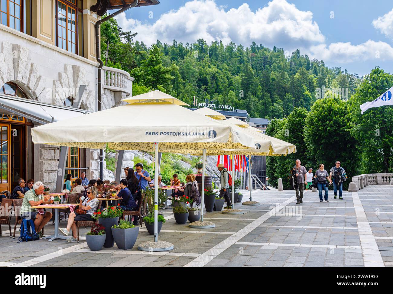 Cafe and sunshade umbrellas outside the entrance to Postojnska Jama (Postojna Cave Park), Slovenia, central & eastern Europe Stock Photo