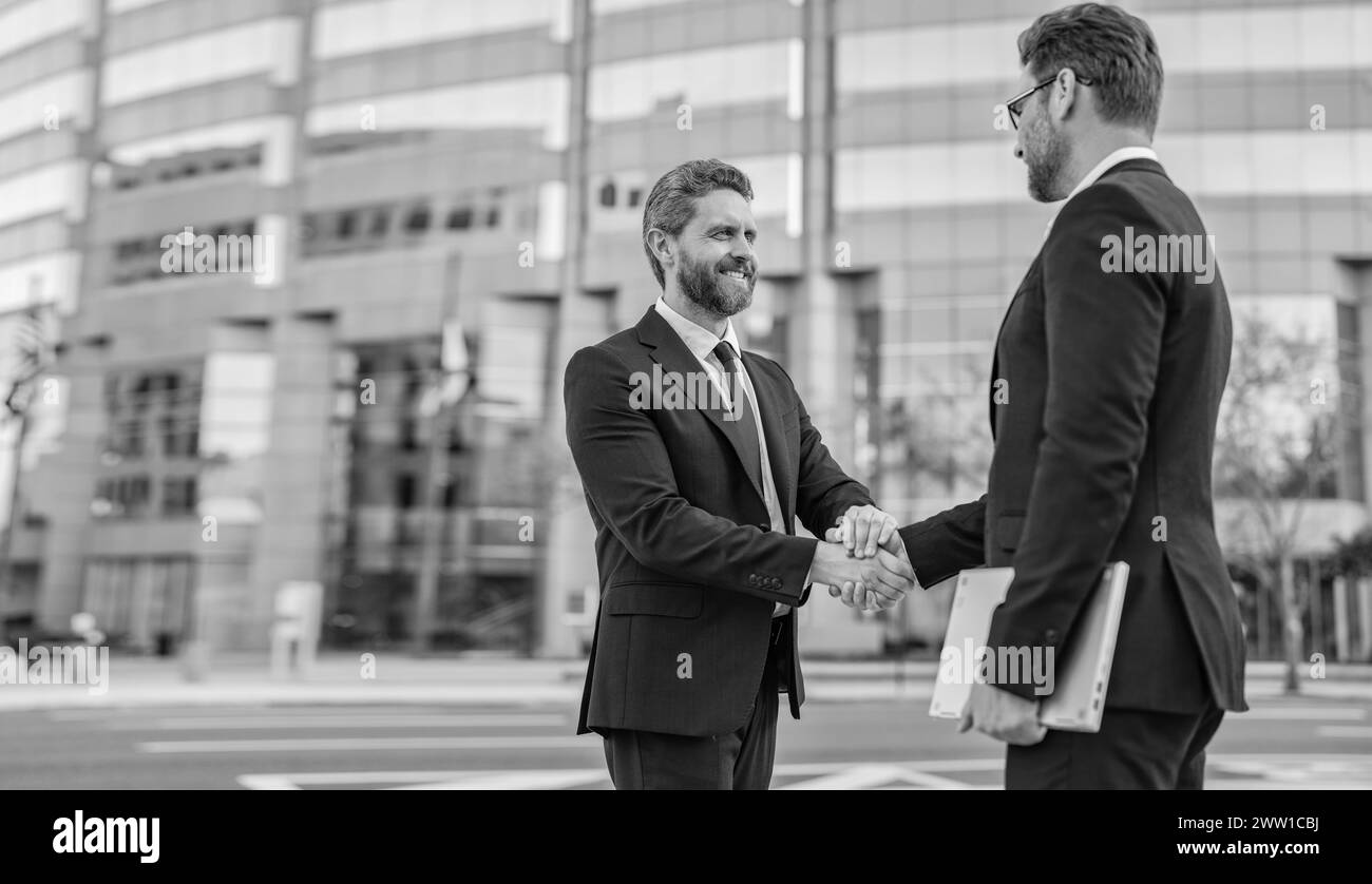 two business men handshaking outdoor, copy space banner. two business ...