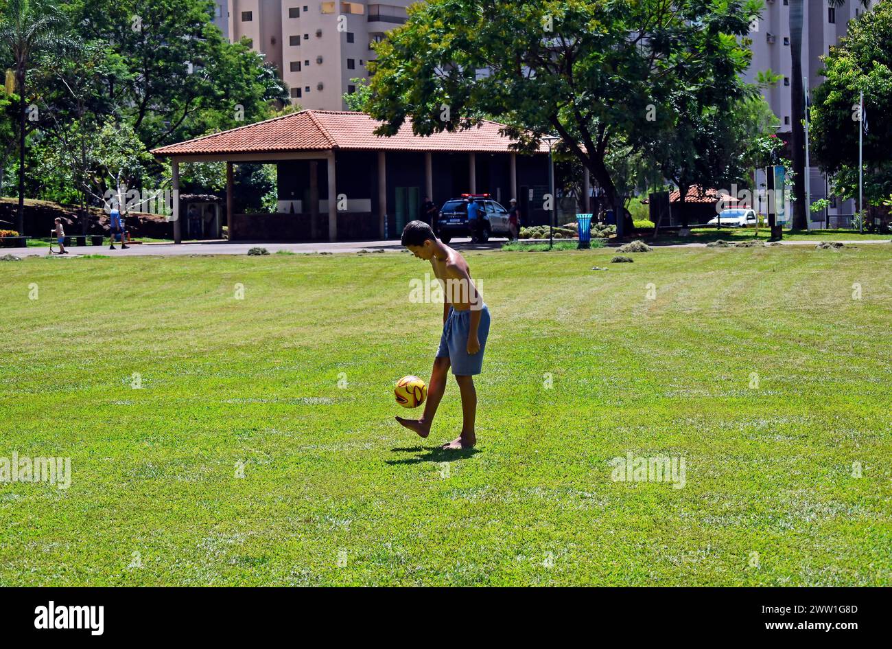 RIBEIRAO PRETO, SAO PAULO, BRAZIL - December 26, 2023: Teenager playing ball on Public park Stock Photo