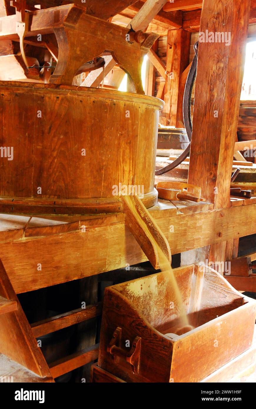 Grain Spills out of a Wooden Hopper at a recreated mill in Historic Sleepy Hollow, New York Stock Photo