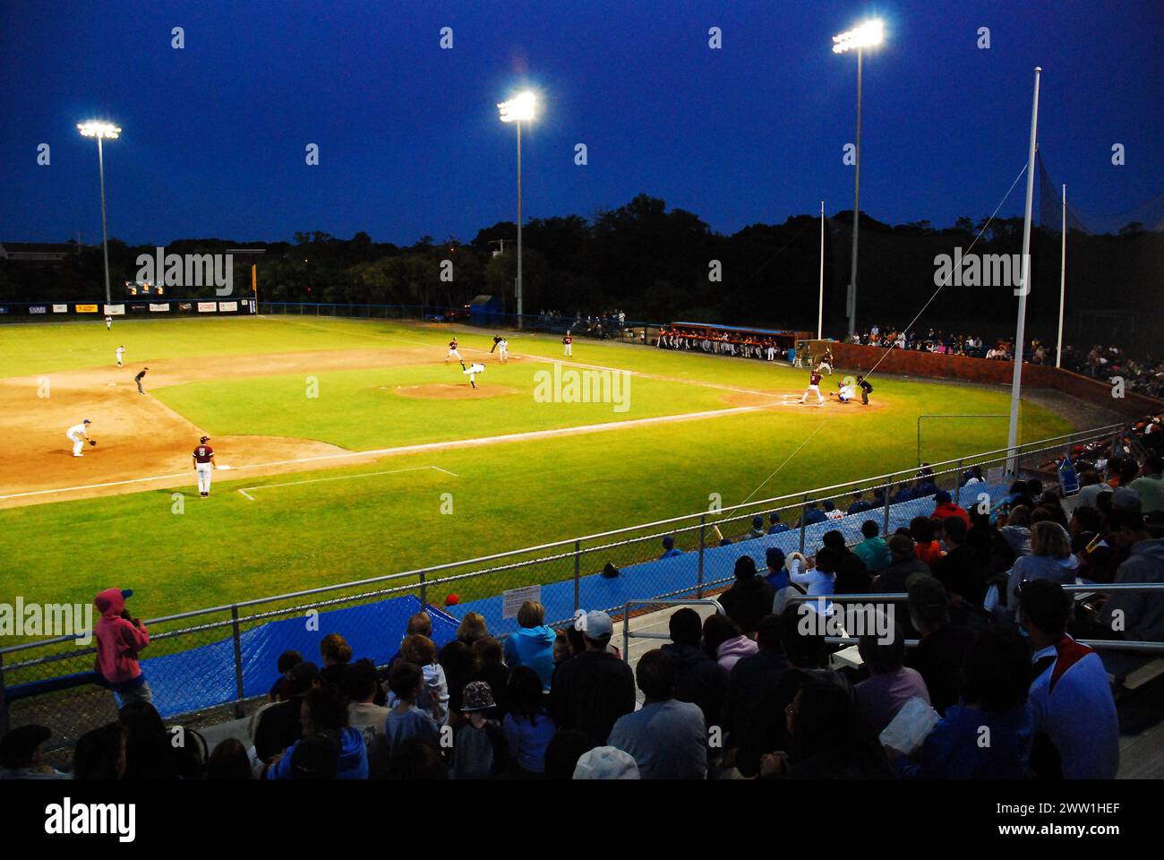 A crowd enjoys a Night Baseball Game in the Cape Cod Baseball League on a summer even9ing Stock Photo