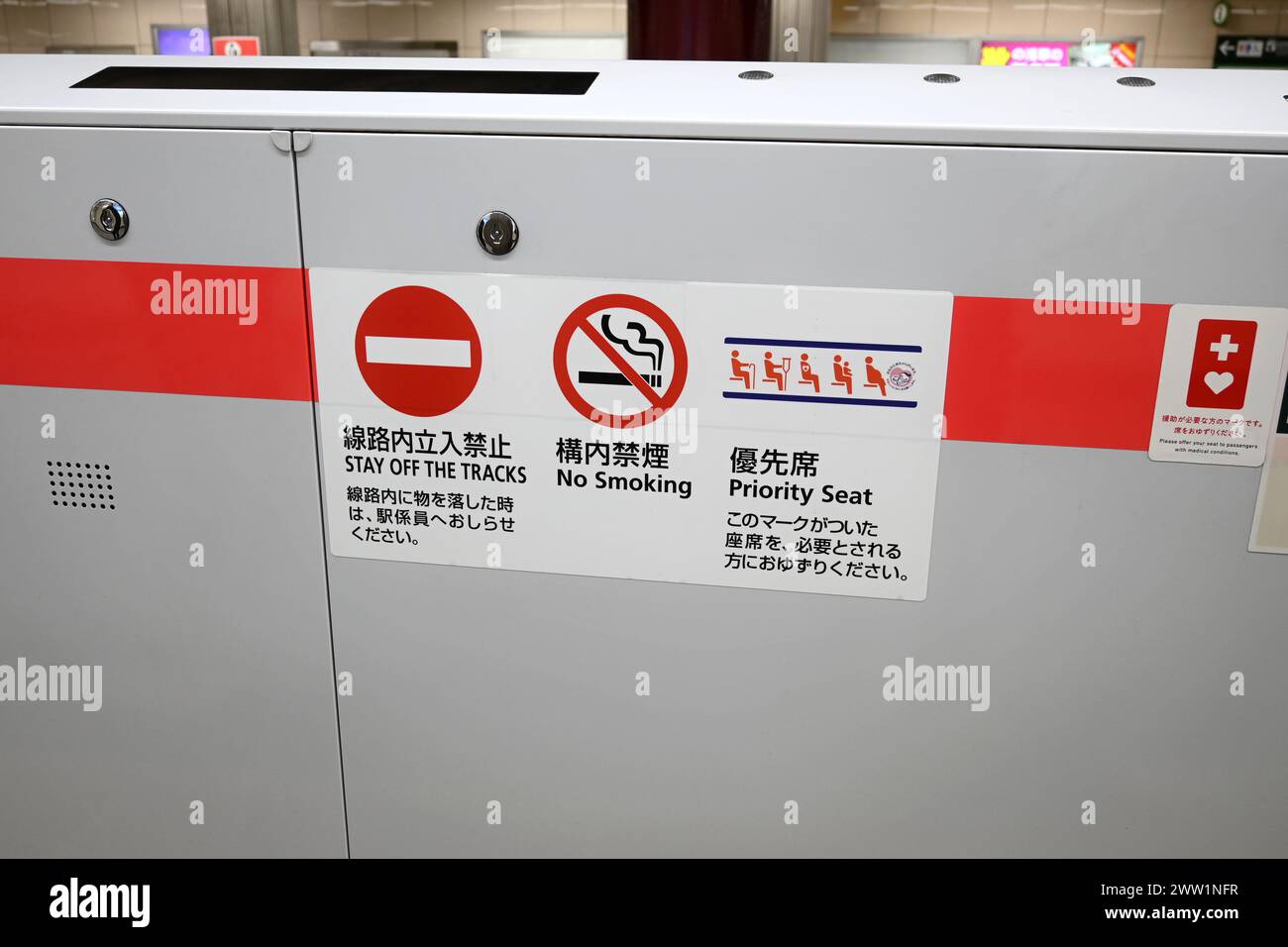 Tokyo Metro safety warning information signs (stay of the tracks,no smoking and priority seat) on barrier – Tokyo, Japan – 27 February 2024 Stock Photo