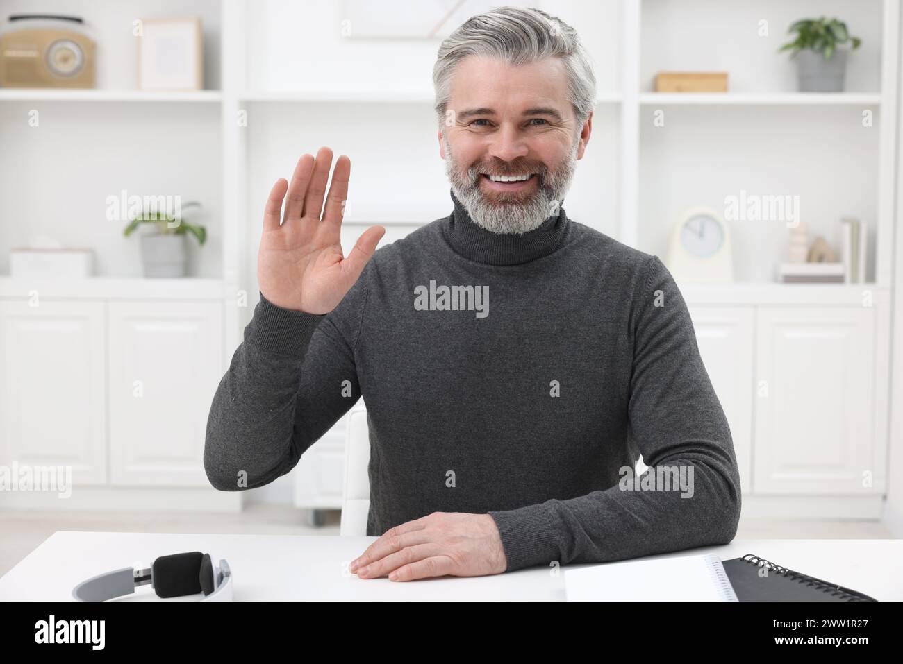 Man waving hello during video chat at home, view from webcam Stock Photo