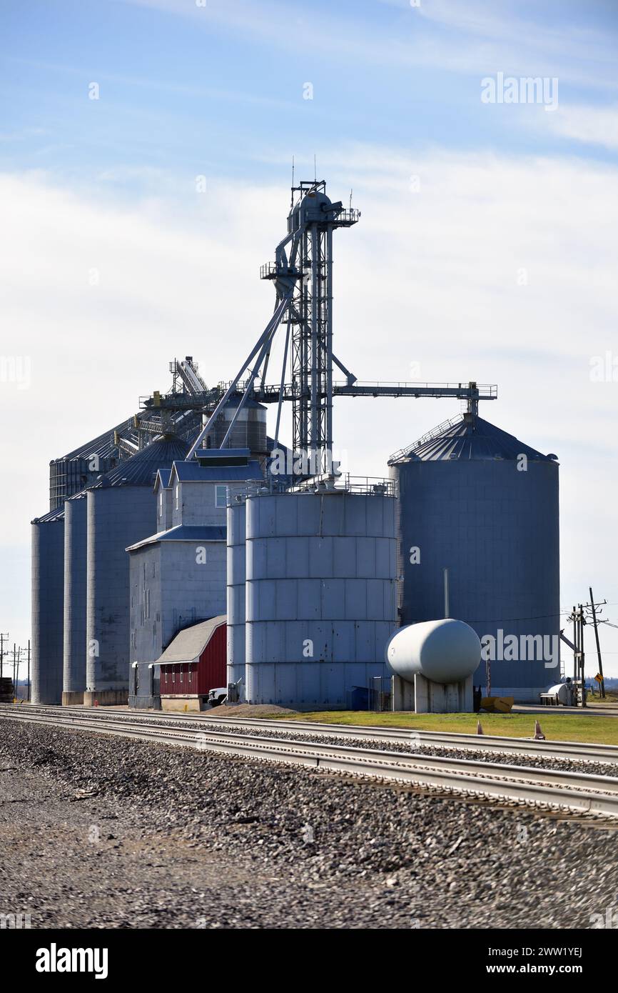 Meriden, Illinois, USA. A farmer's cooperative with a series of grain elevators and storage structures sets along a railroad mainline. Stock Photo