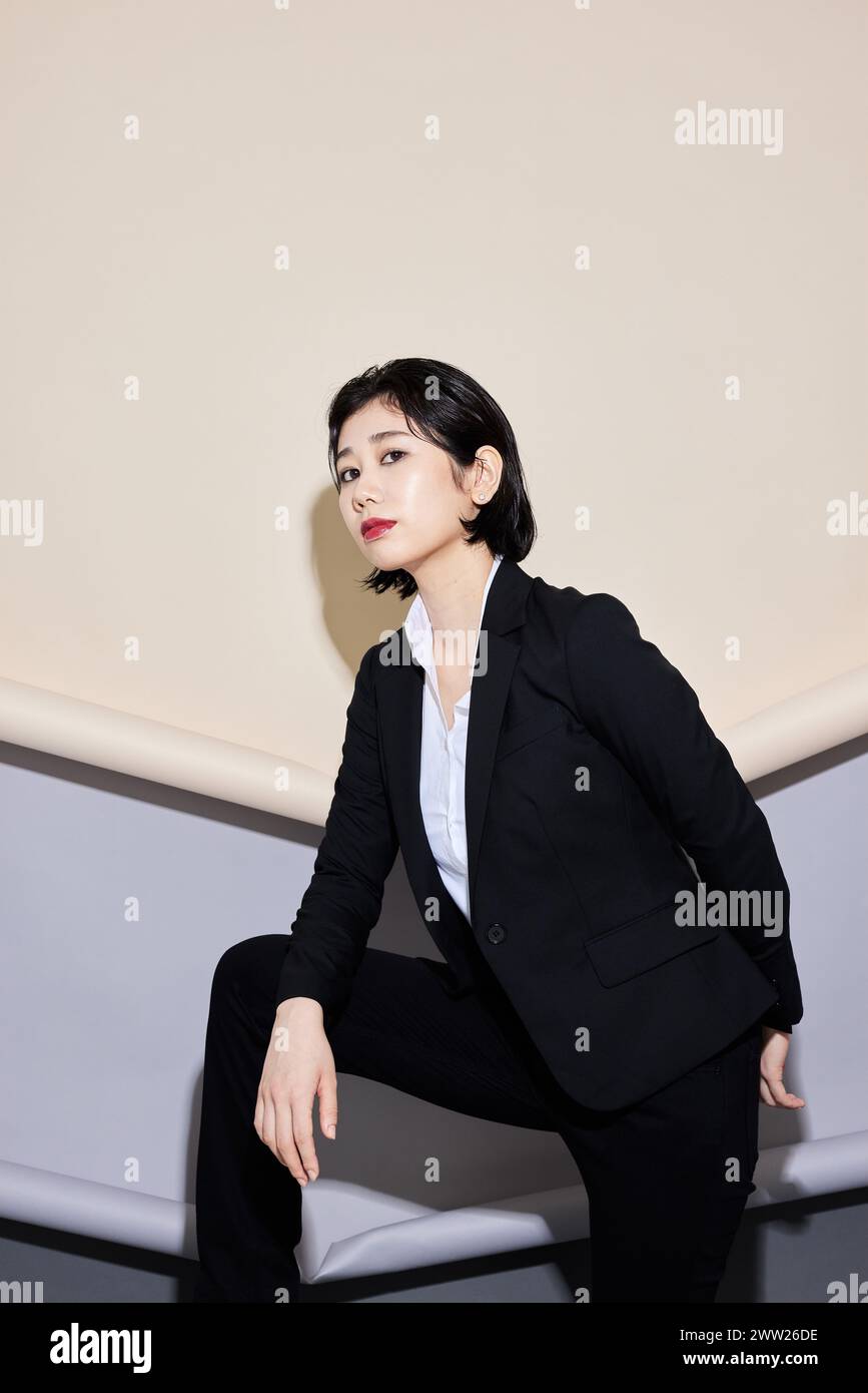 A woman in a black suit and white shirt Stock Photo