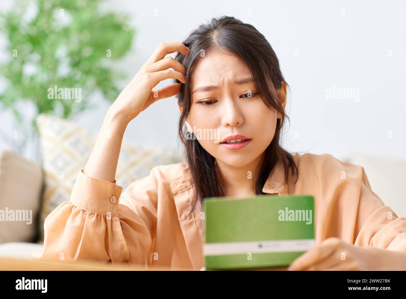 Woman holding a bank note and looking at it Stock Photo
