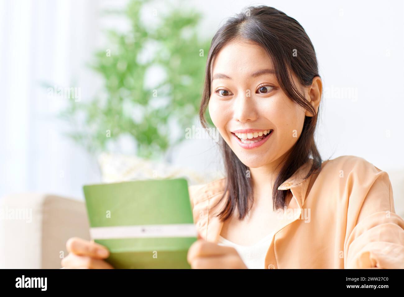 A woman smiling while holding a bank note Stock Photo
