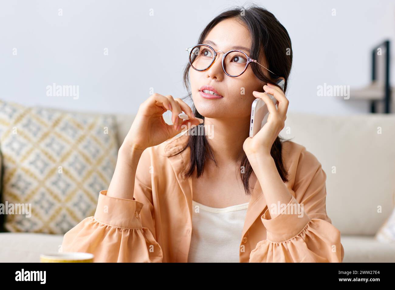 A woman in glasses talking on the phone Stock Photo