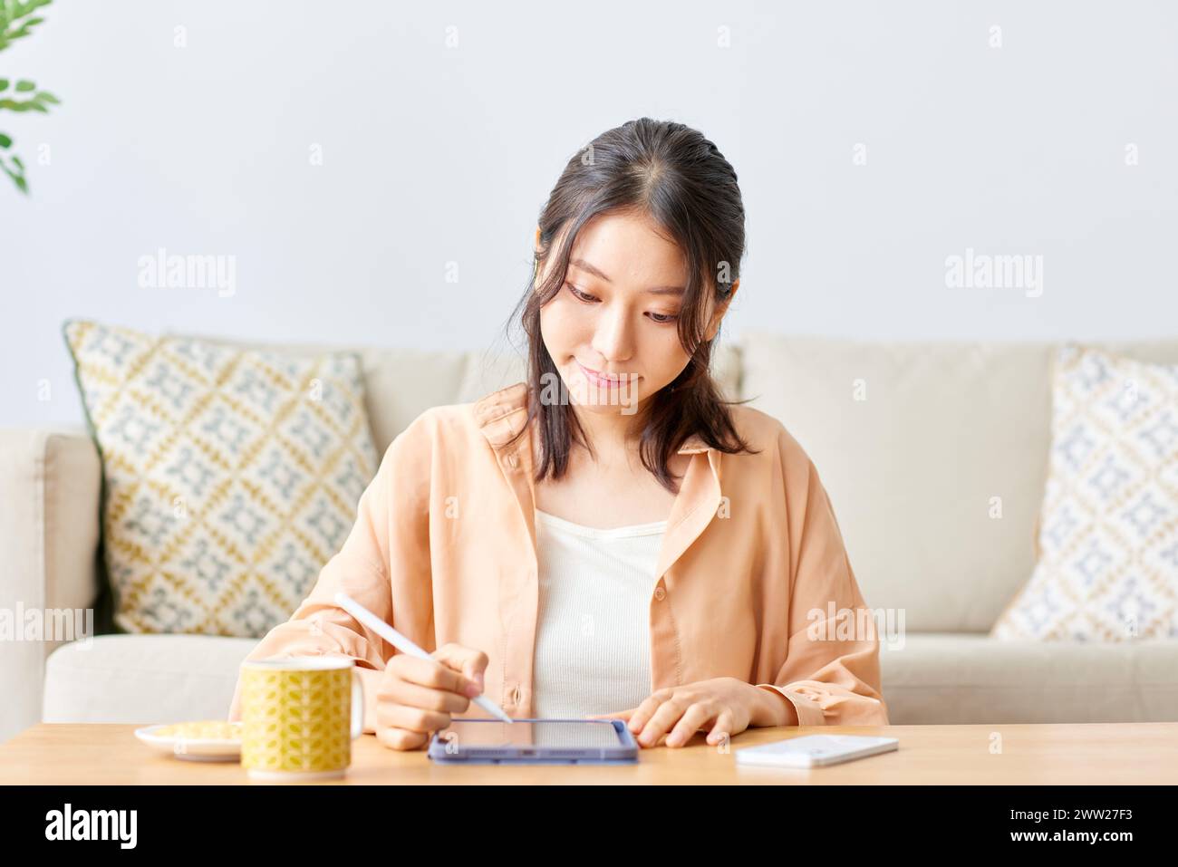 Asian woman using tablet computer at home Stock Photo