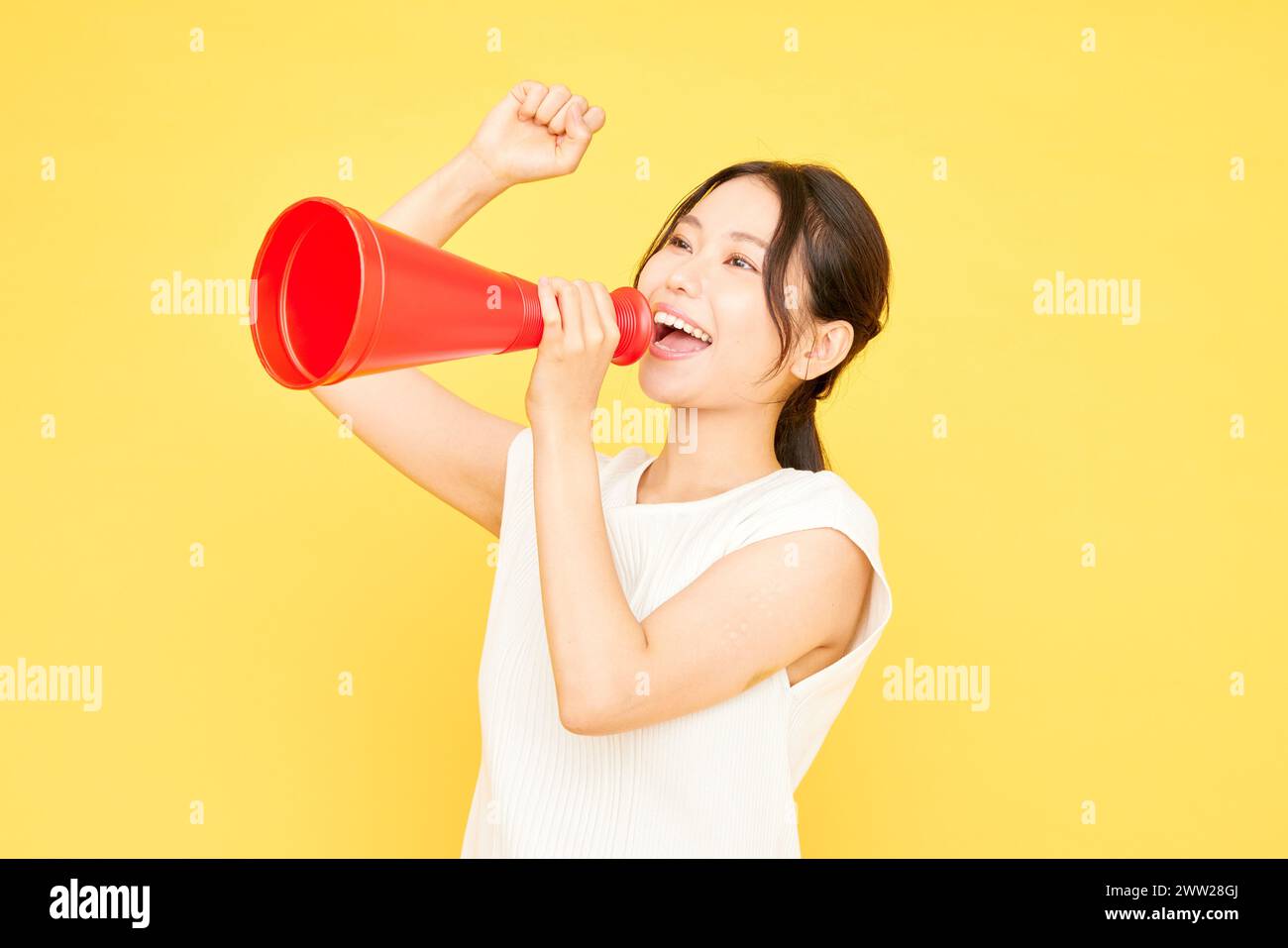 Asian woman shouting into a megaphone Stock Photo