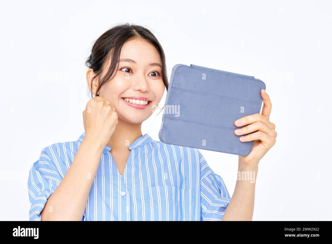 A woman holding a tablet computer in front of her face Stock Photo