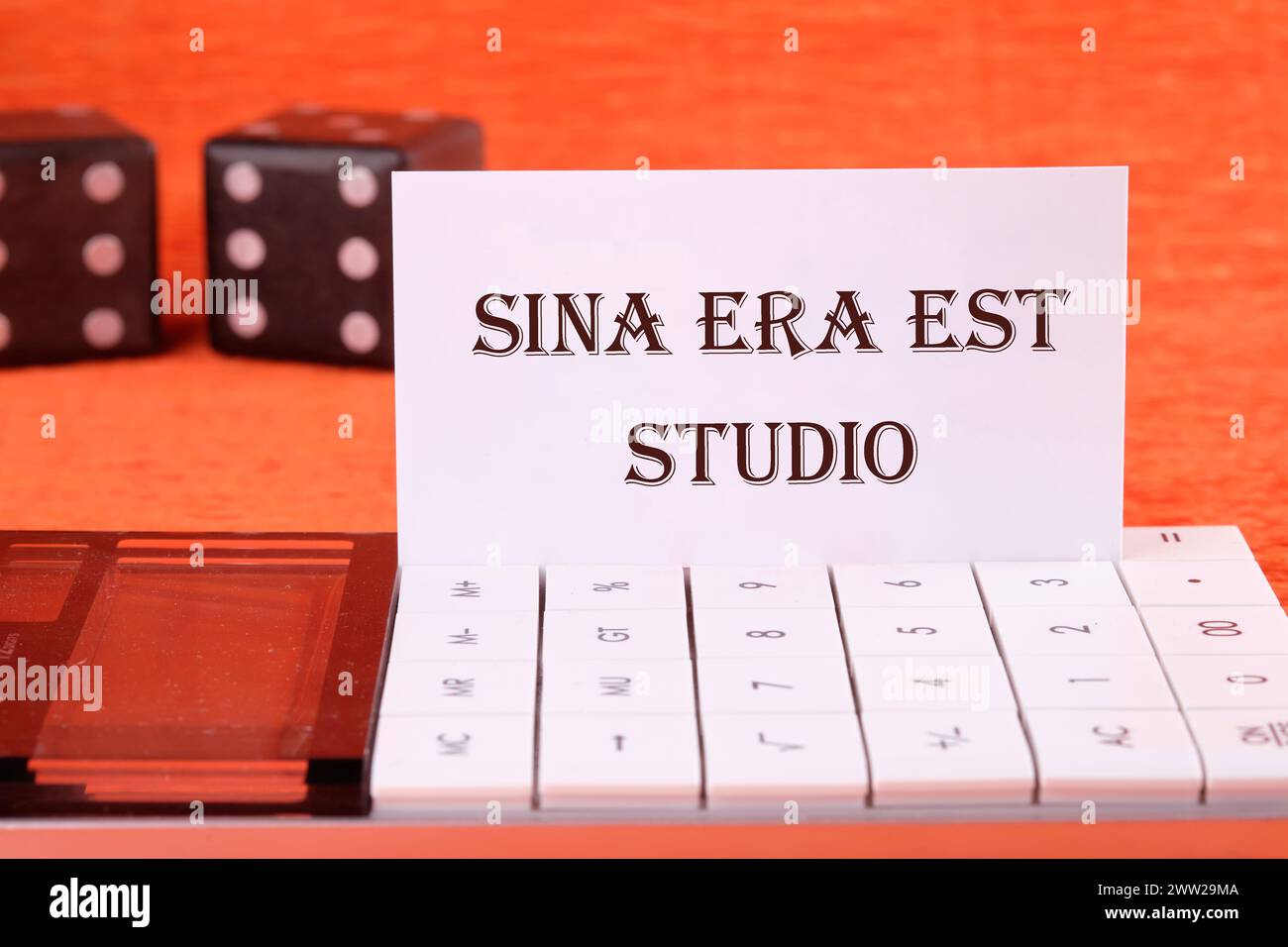 Sina era est studio It means Without anger and addiction on a white business card on a calculator on an orange background Stock Photo