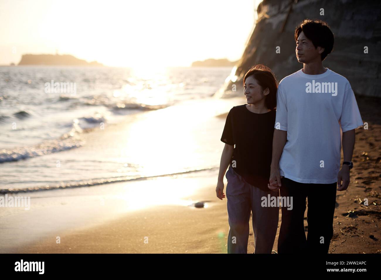 A man and woman walking on the beach Stock Photo - Alamy