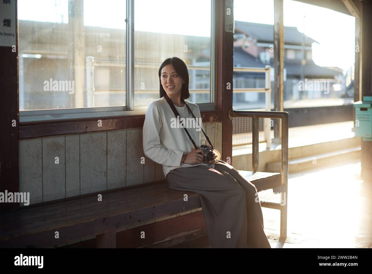 A woman sitting on a bench Stock Photo - Alamy