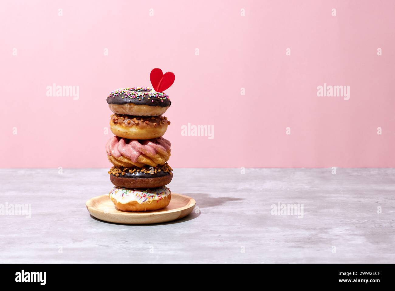 A stack of donuts with sprinkles and a heart on top Stock Photo - Alamy