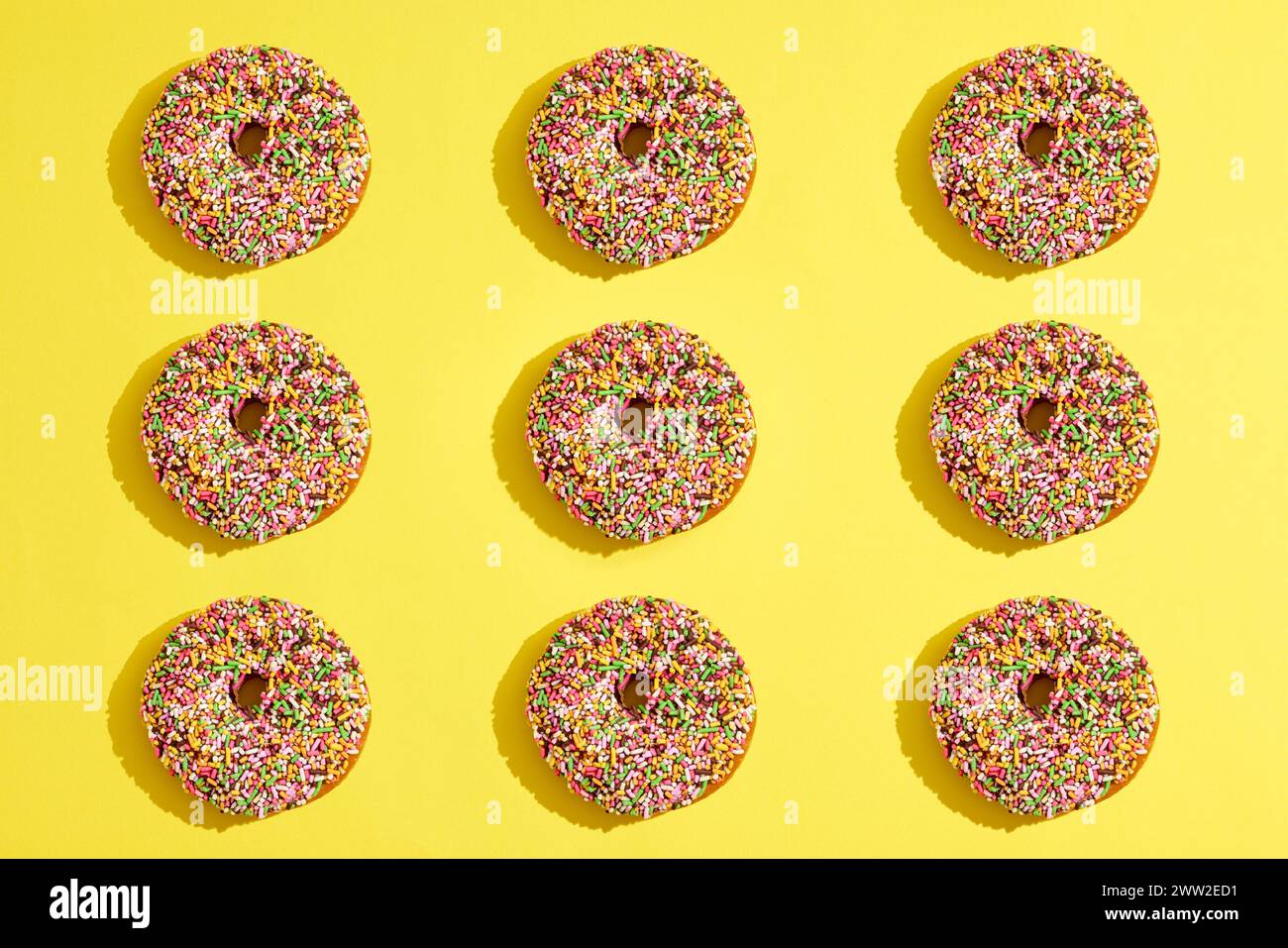 Donuts arranged on a yellow background Stock Photo
