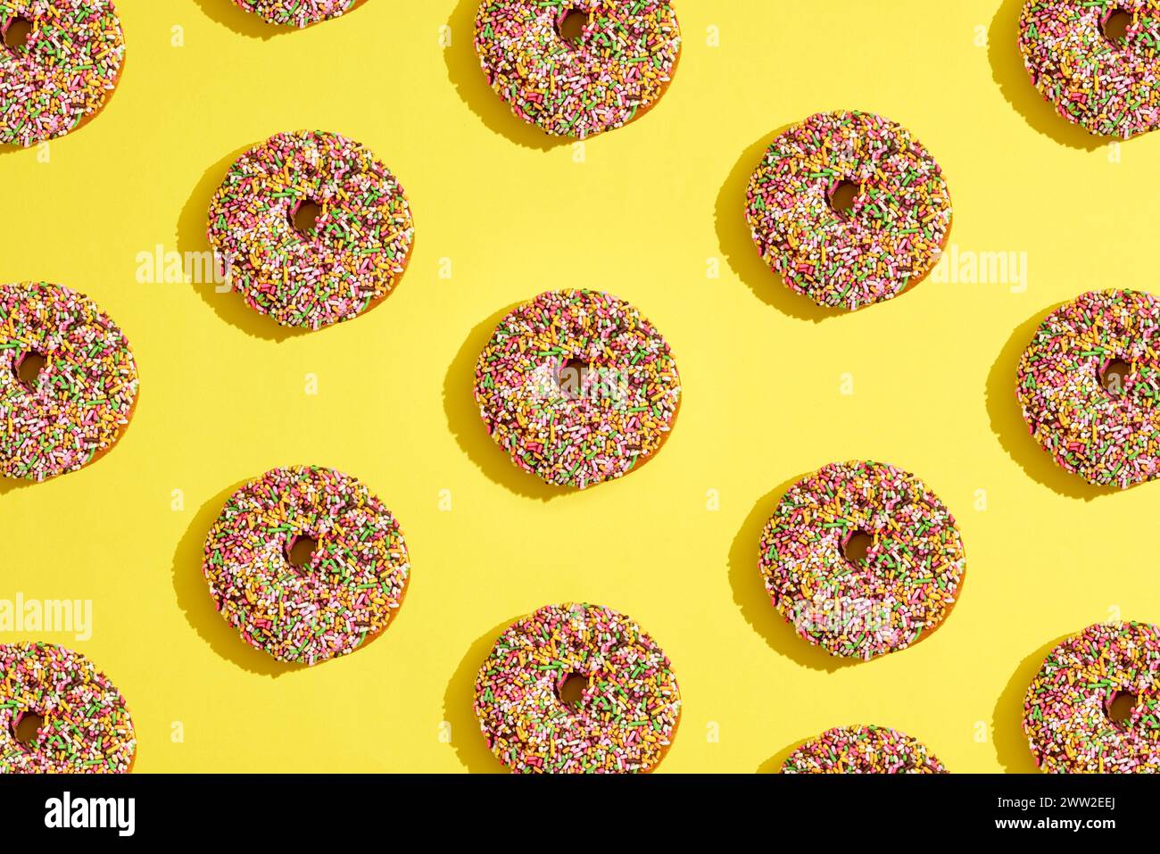 A pattern of donuts on a yellow background Stock Photo - Alamy