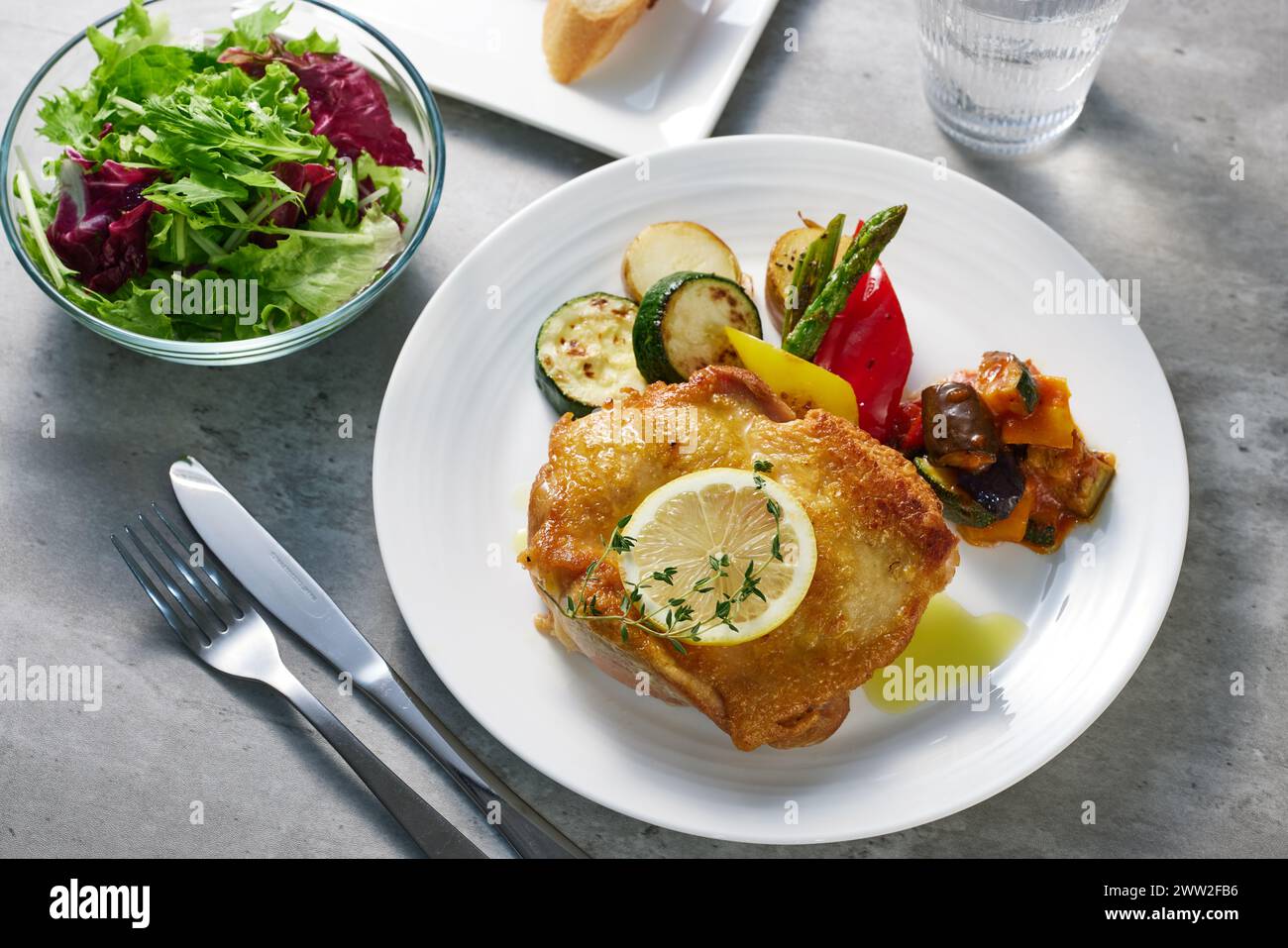 A plate with a chicken breast and vegetables Stock Photo